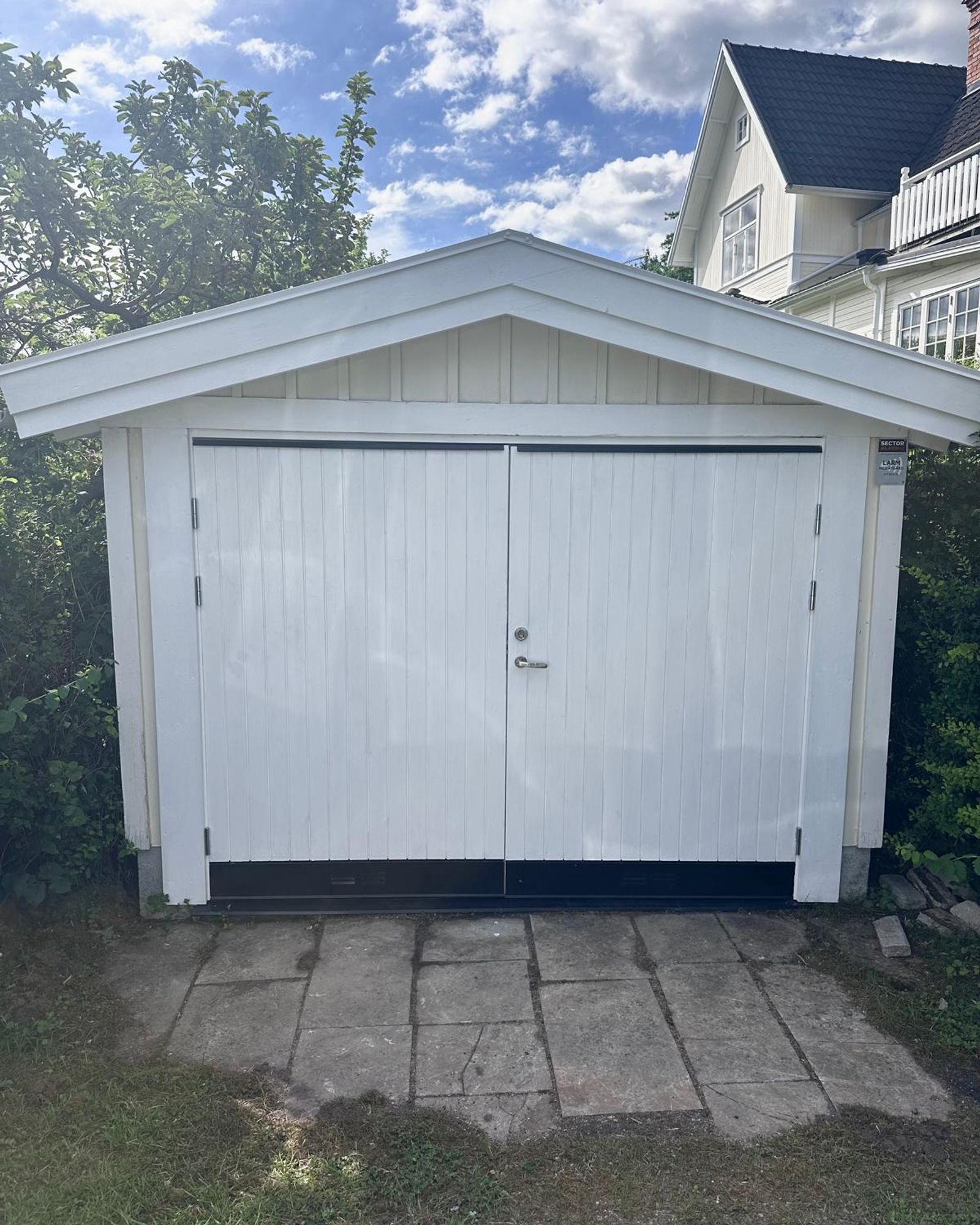 Ny vit garageport på renoverat garage i Bromma
