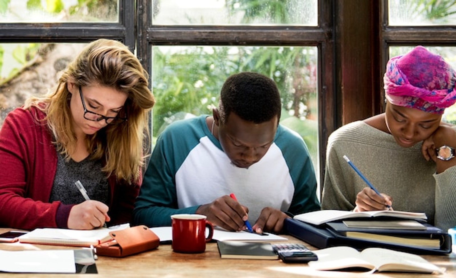three students heads down studying