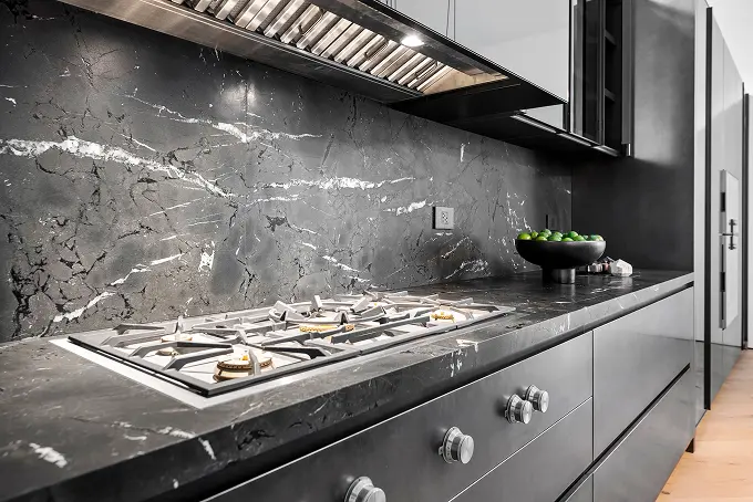 Sleek modern kitchen finished entirely in dramatic black stone surfaces.