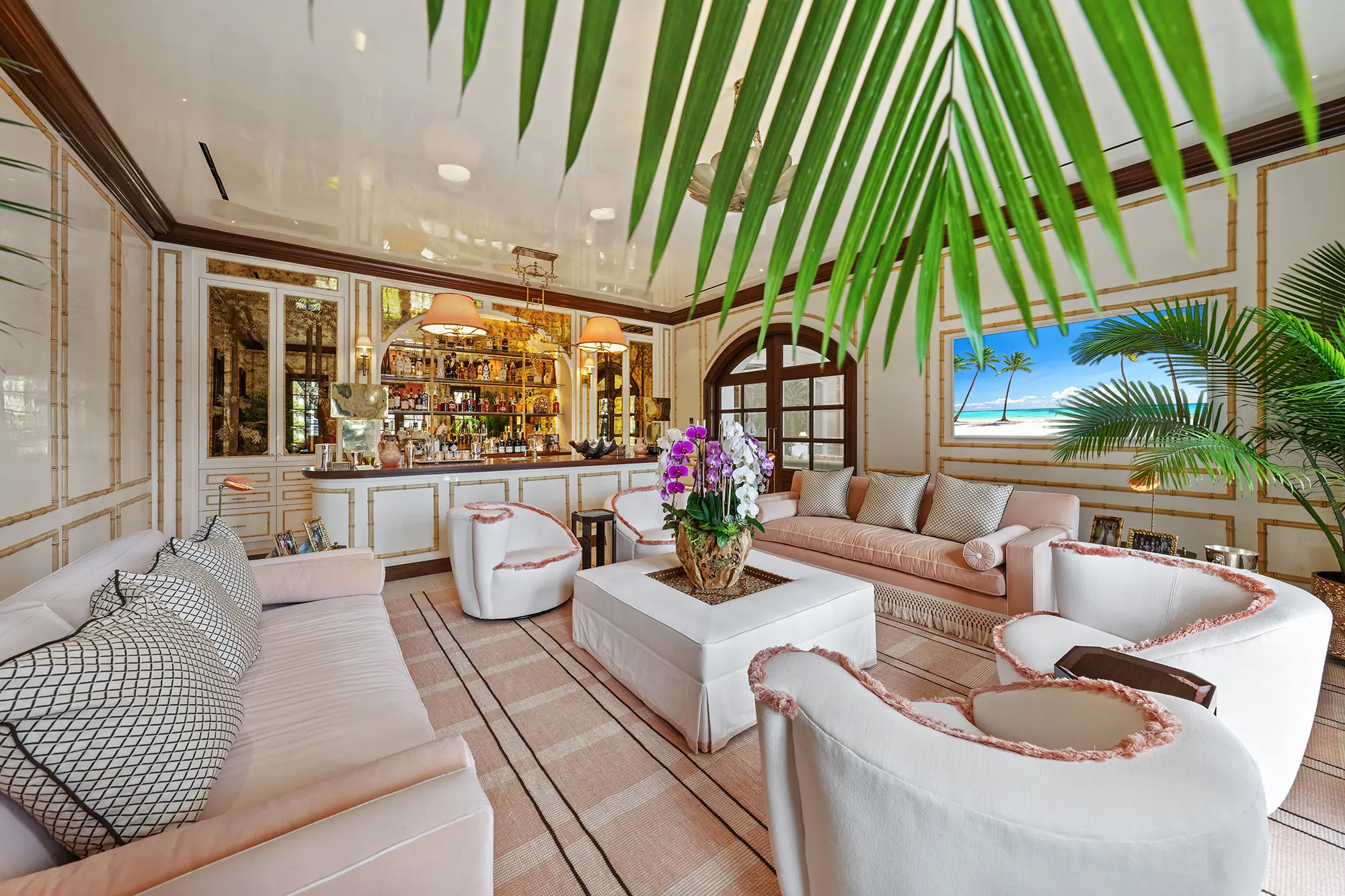 Luxury lounge with custom seating, home bar and tropical accents.