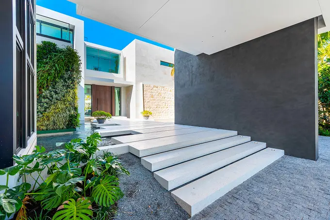 Steps lead into a modern open-air courtyard centered around a tranquil water feature.