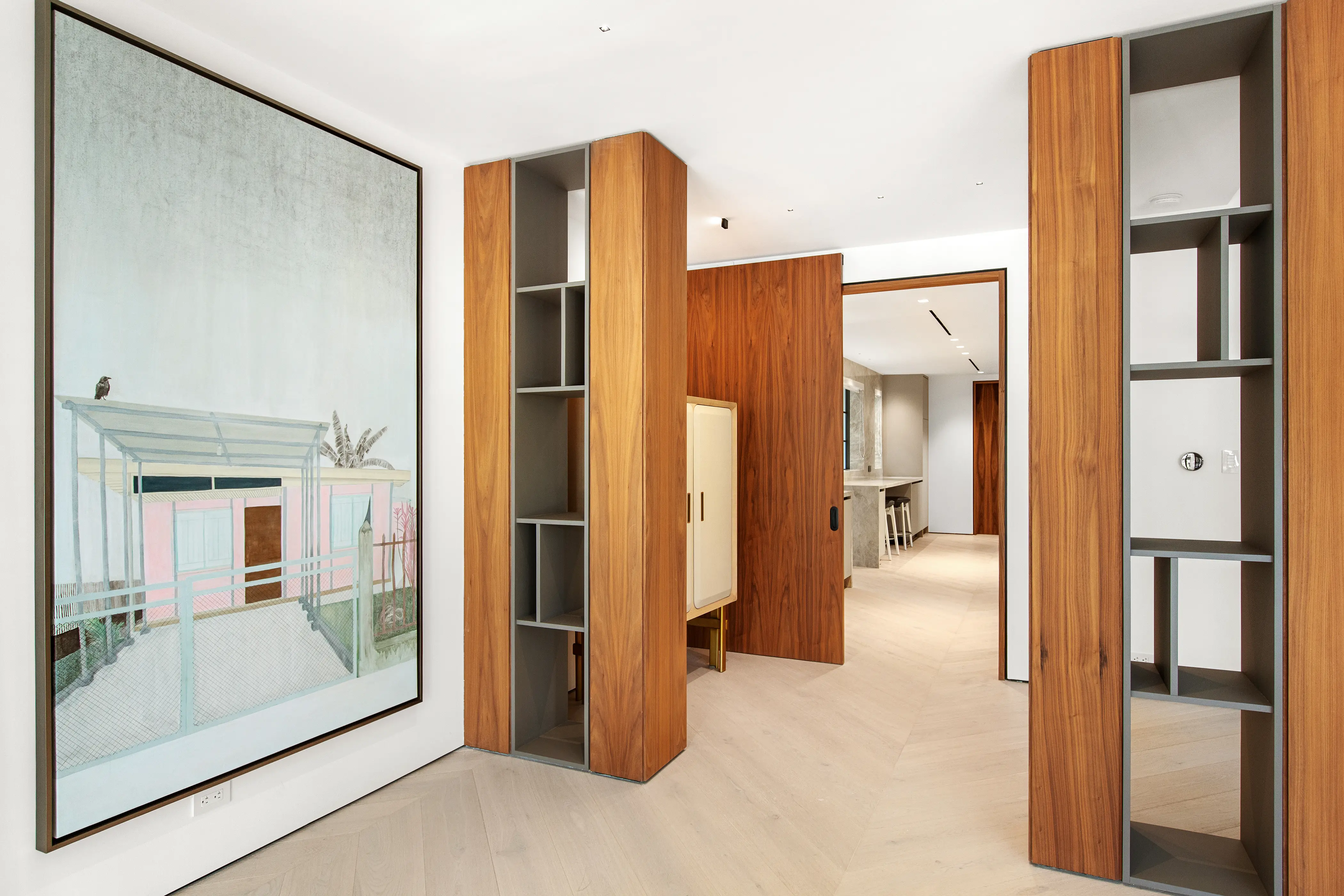 Custom floor-to-ceiling wood millwork with integrated shelving and concealed storage, showcasing refined craftsmanship in a contemporary Miami Beach interior.