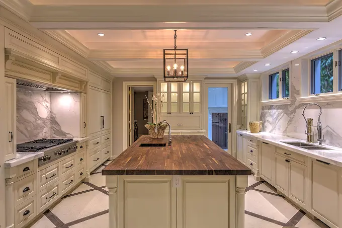 Modern classic kitchen with a butcher block island and white marble countertops.