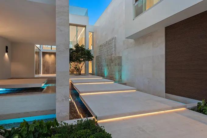 Modern entryway leading into the courtyard, beautifully illuminated at night.
