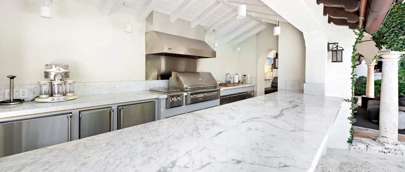 Outdoor kitchen and bar featuring sleek marble countertops for al fresco entertaining.