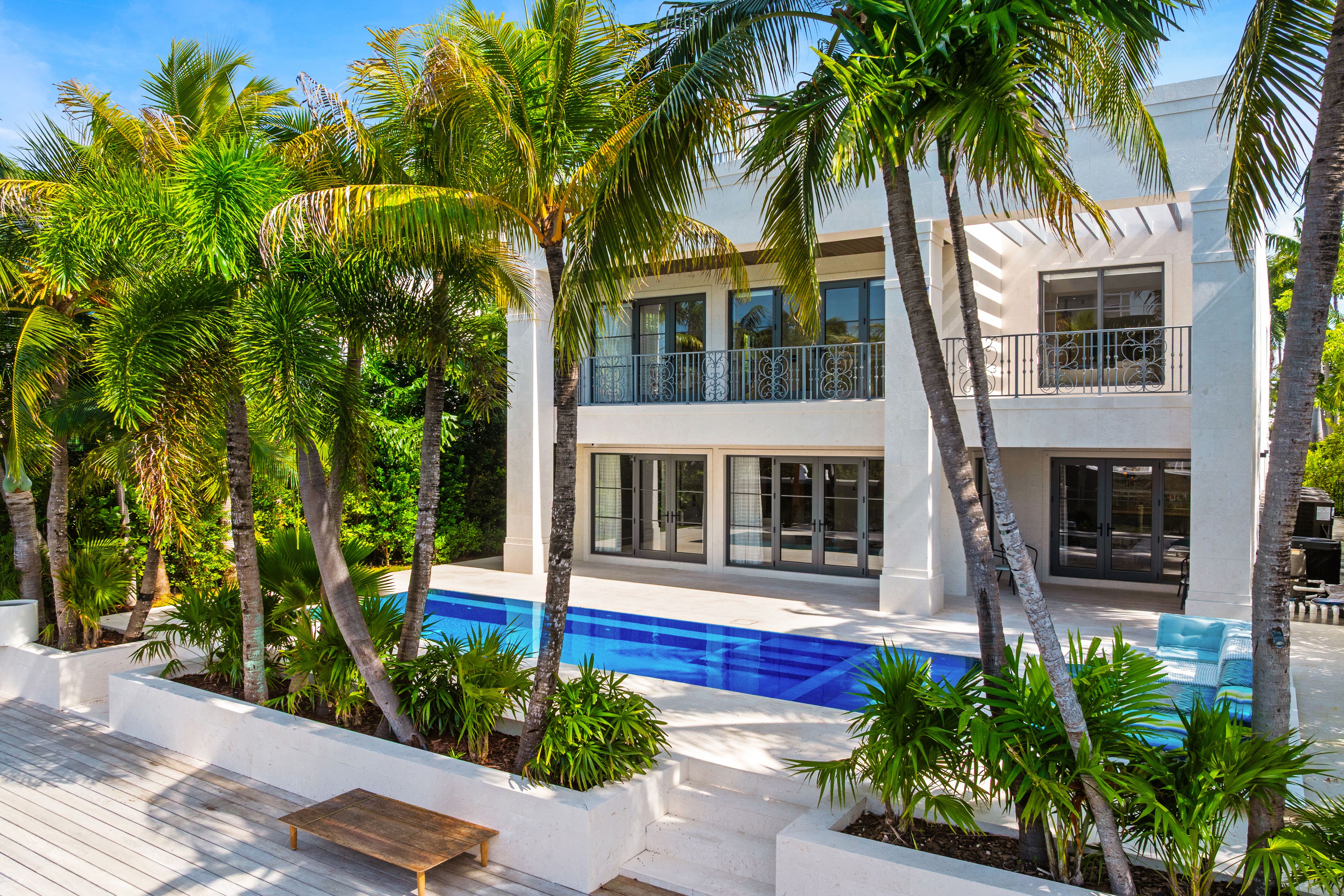 Contemporary luxury residence in Miami Beach featuring clean architectural lines, natural stone finishes, tropical landscaping, and a refined modern entrance.