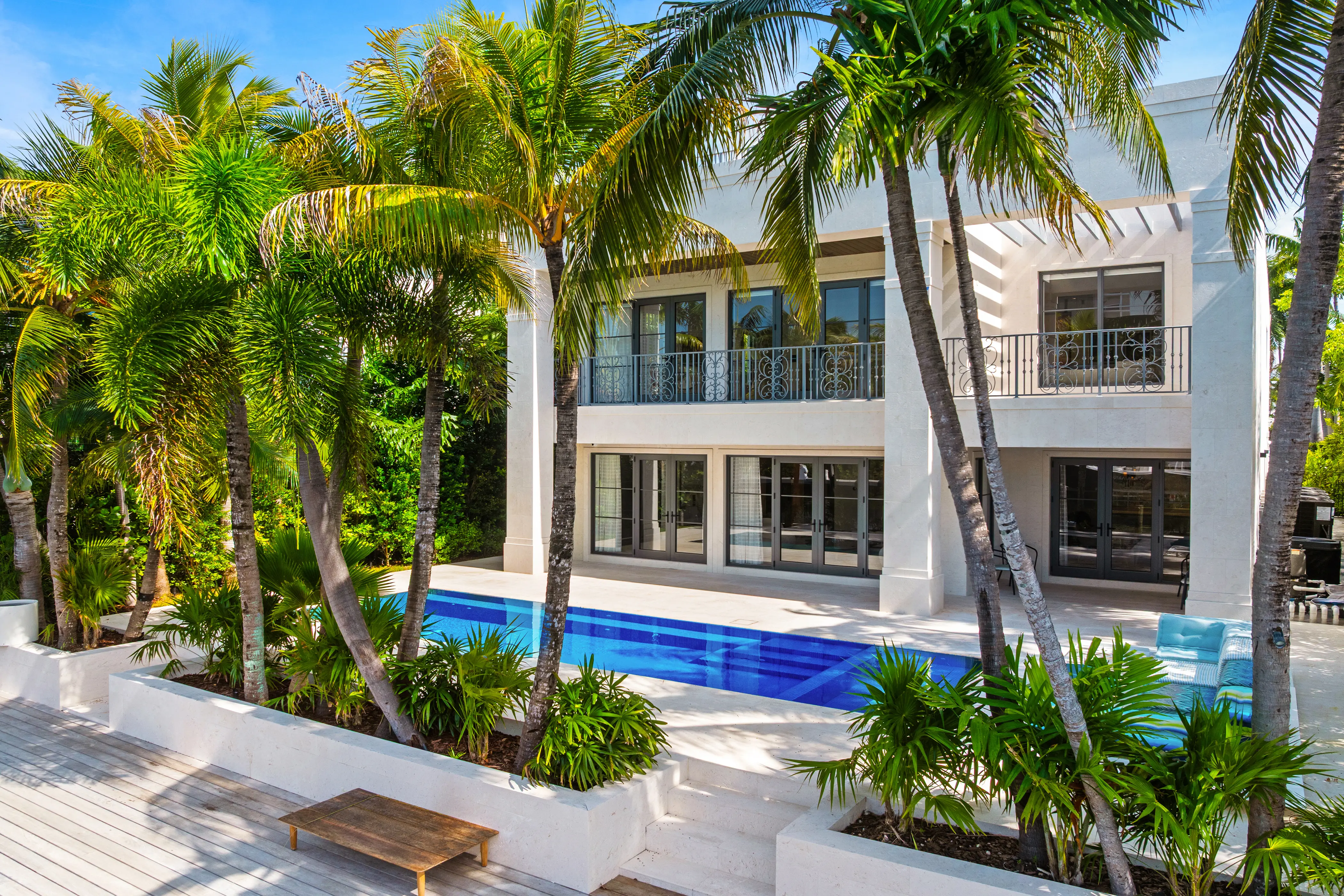 Contemporary luxury residence in Miami Beach featuring clean architectural lines, natural stone finishes, tropical landscaping, and a refined modern entrance.