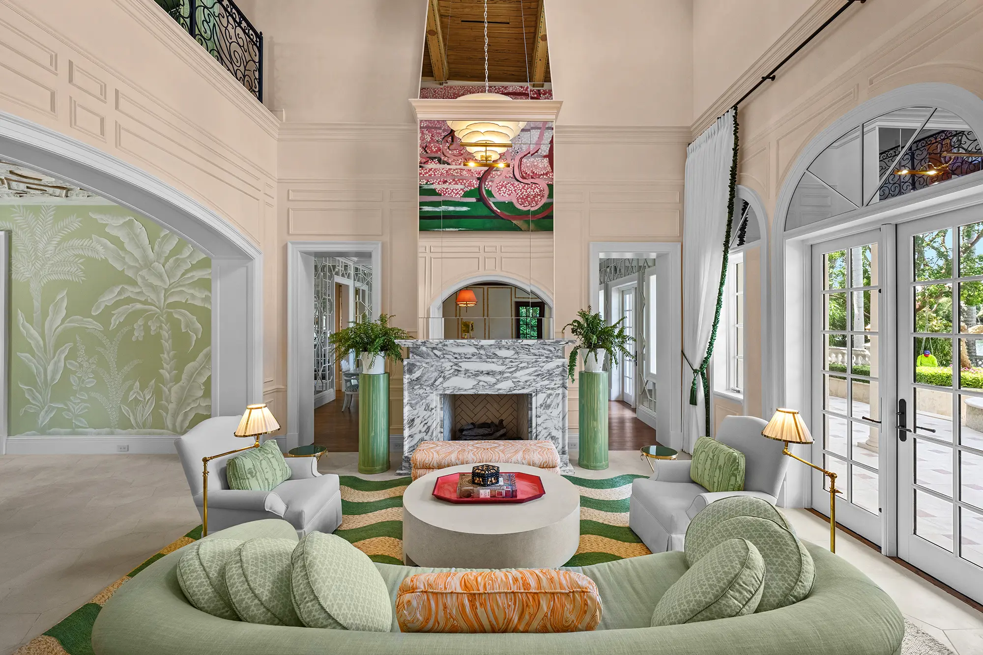 Double-height luxury living room with marble fireplace and custom furnishings.
