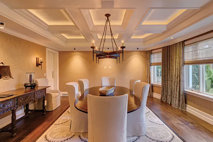 Formal dining room featuring a classical recessed ceiling and ambient lighting.