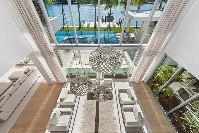 Bird's-eye view of the living room's two-story glass windows overlooking the pool and lake.