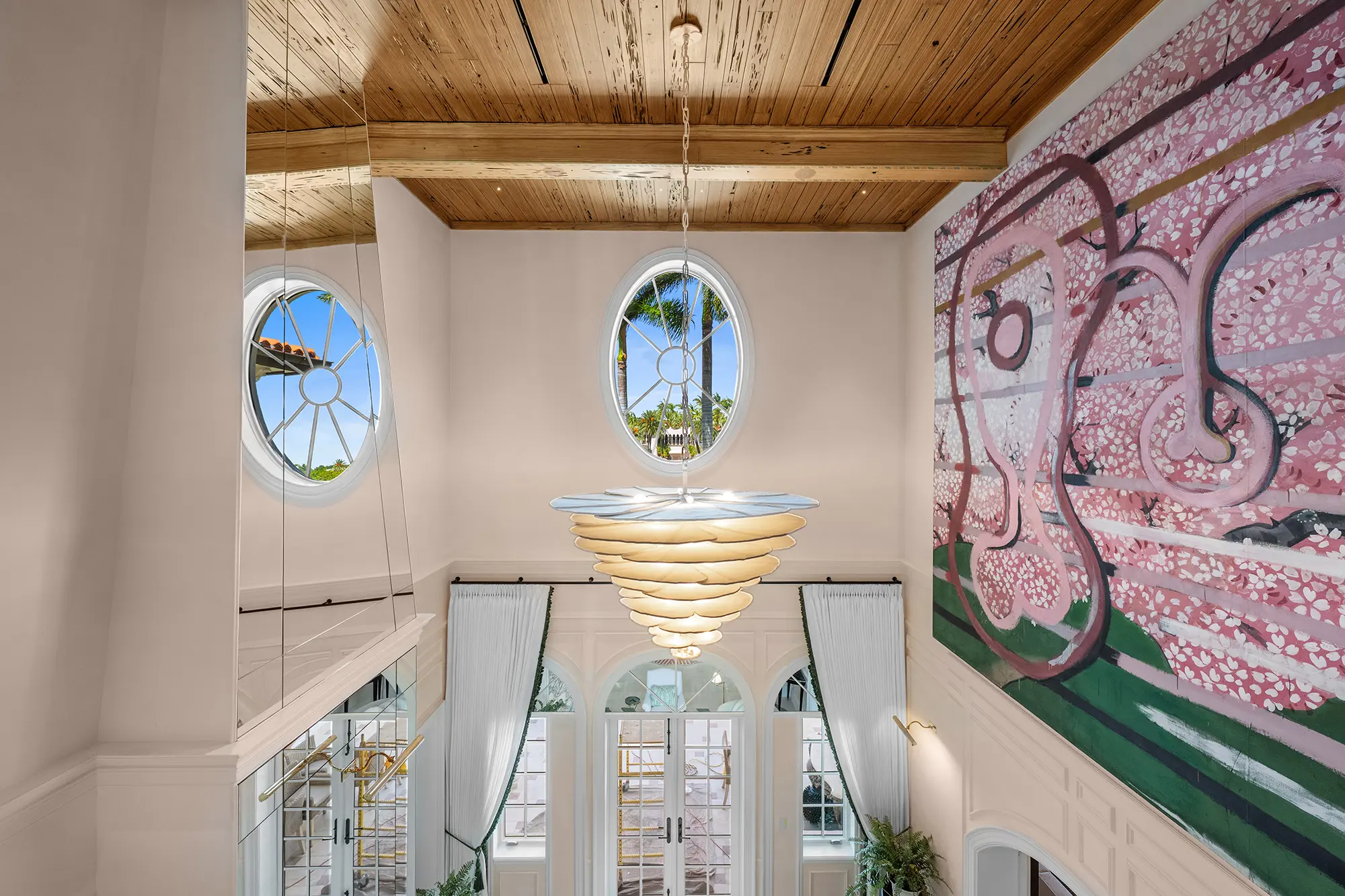 Double-height luxury interior with statement art and sculptural lighting.