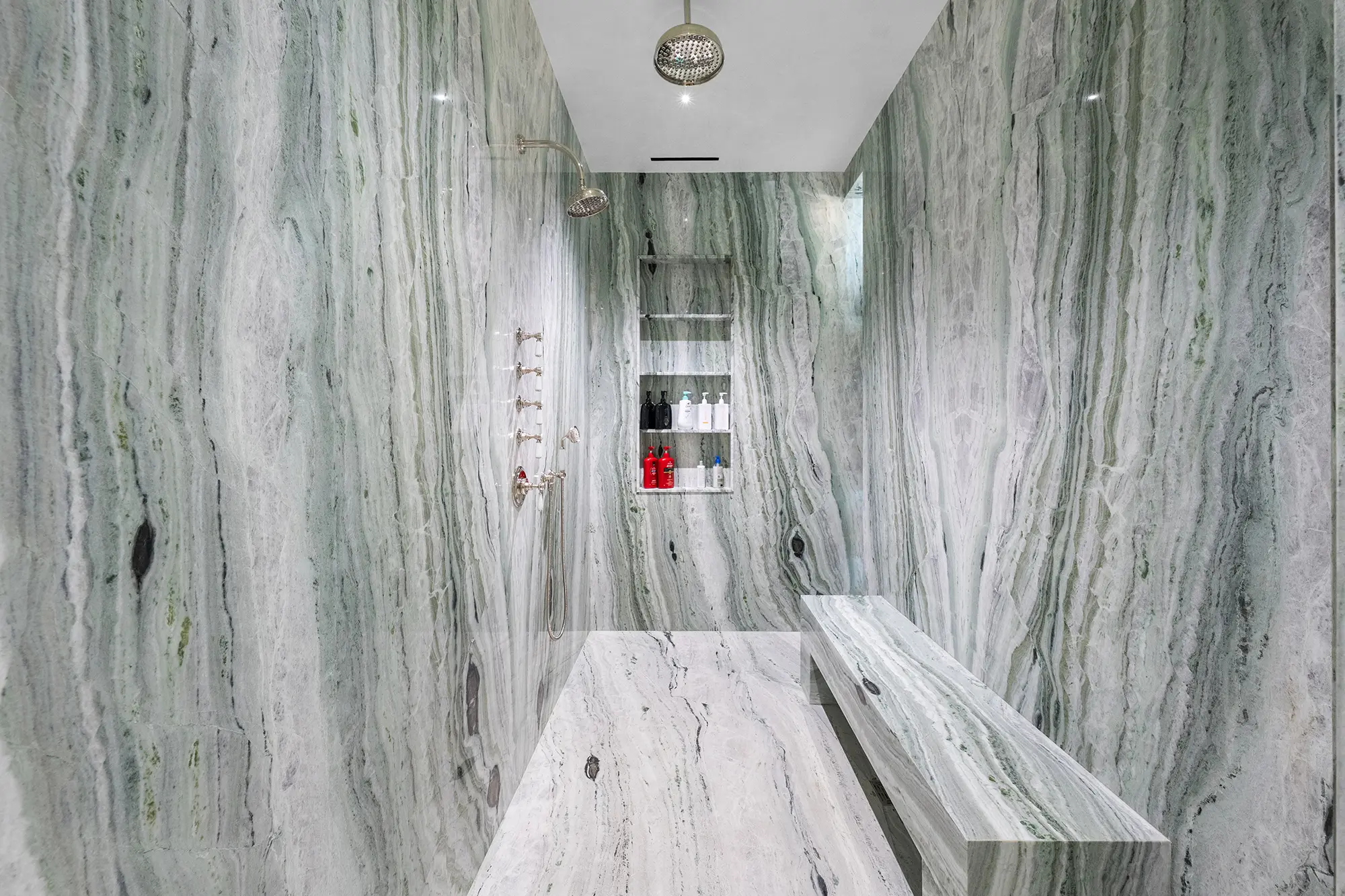 Luxury walk-in shower with natural stone and custom bench.