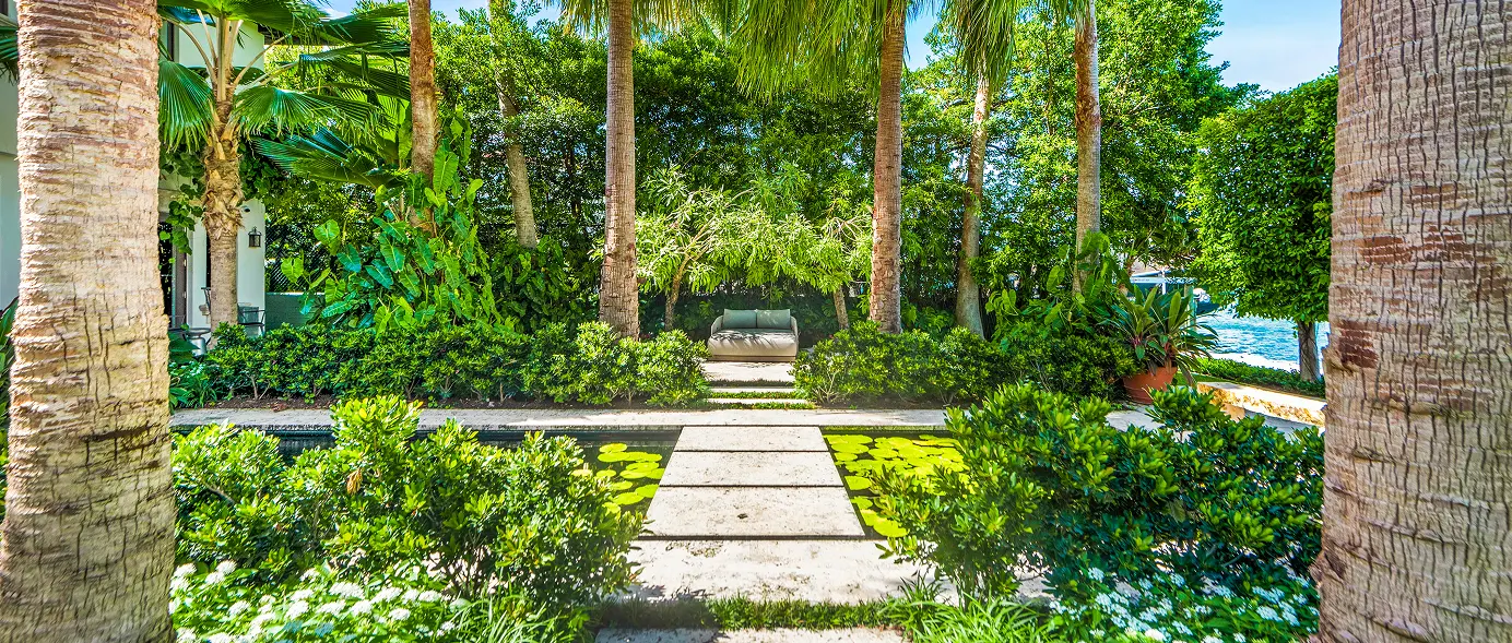 Ocean-side courtyard crossroad surrounded by lush garden landscaping and palm trees.