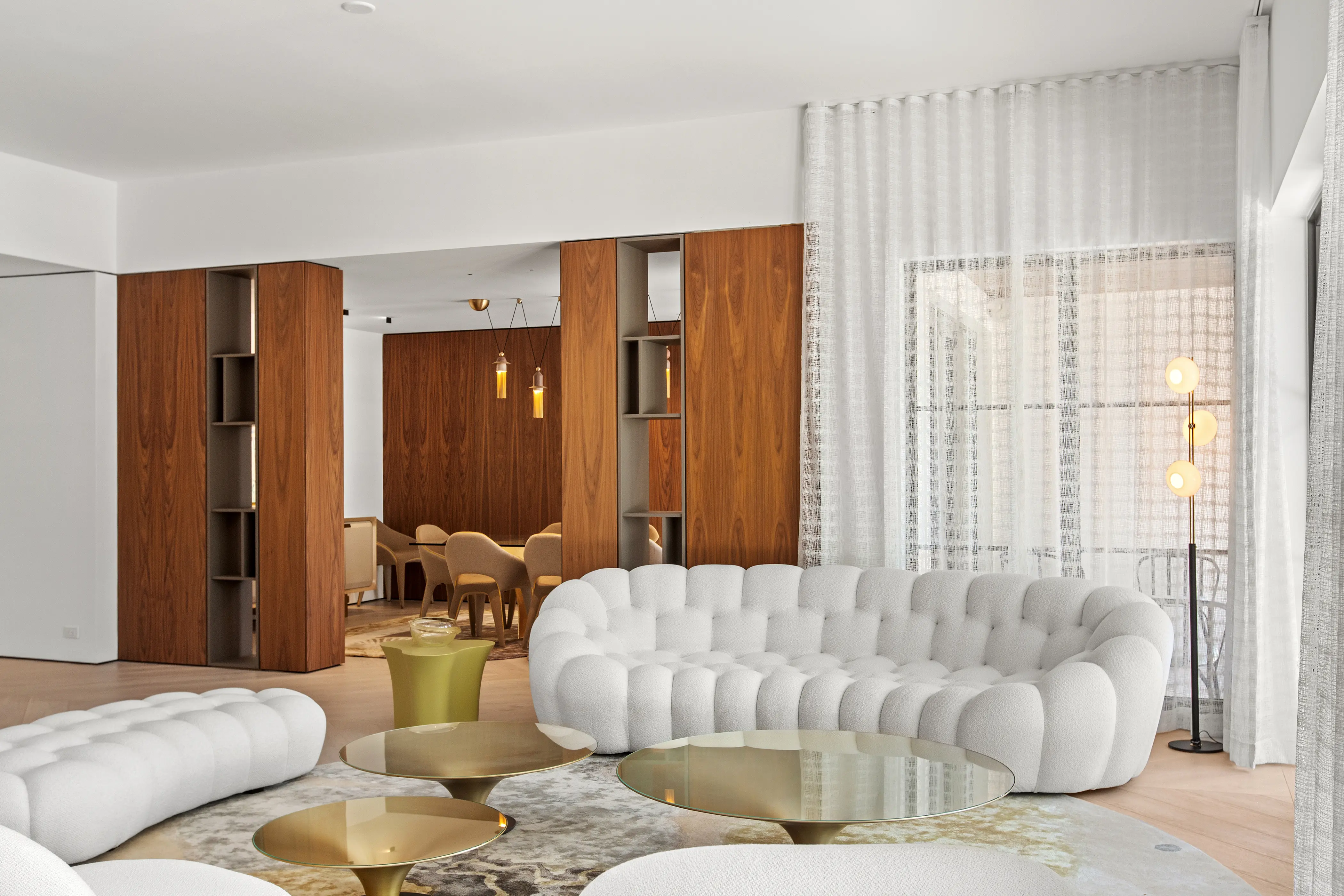 Refined living space featuring custom wood millwork, built-in shelving, sculptural furnishings, and warm contemporary architectural details.