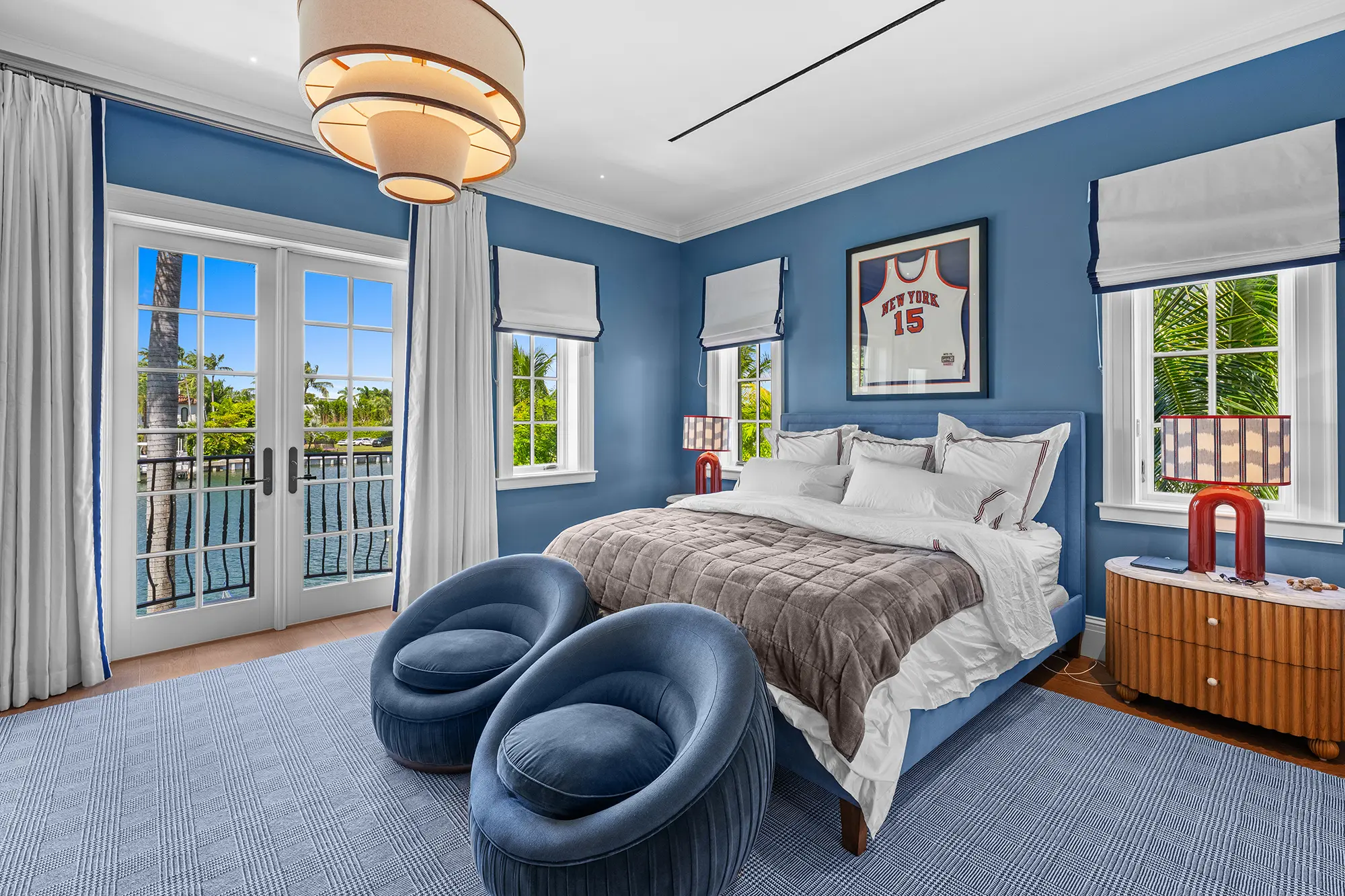 Luxury waterfront bedroom with custom furnishings and blue accents.