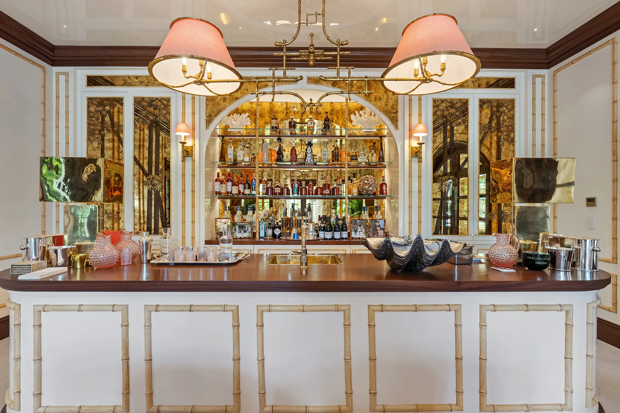 Luxury home bar with custom cabinetry, brass and mirrored details.
