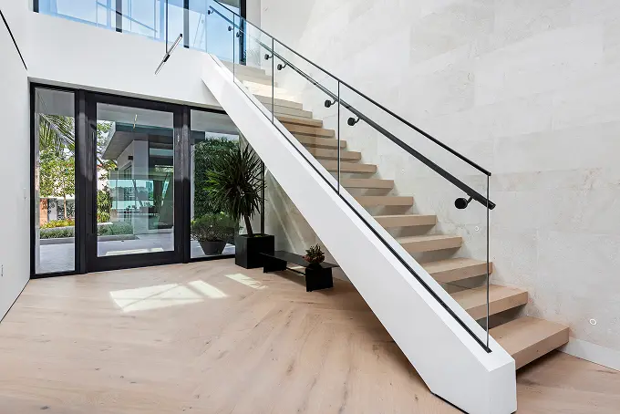 Spacious modern landing featuring a glass-railed staircase and clean architectural lines.