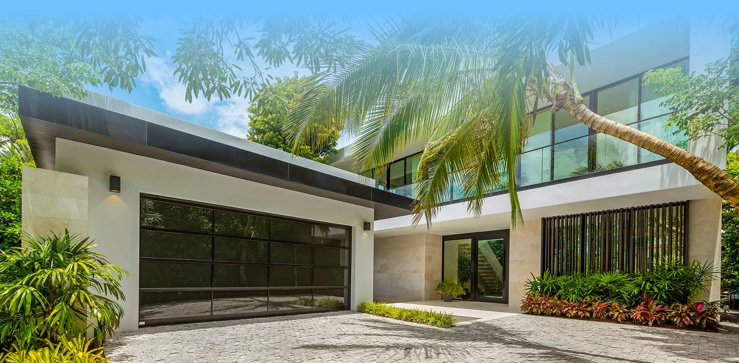 Modern luxury waterfront residence with vibrant blue infinity pool, contemporary architecture, and lush tropical landscaping