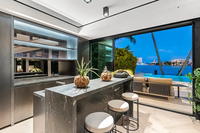 Sleek black marble bar overlooking the pool and bay beyond.