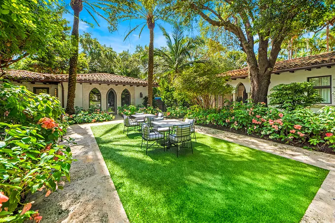 Expansive central courtyard filled with verdant greenery and classic Spanish architectural details.
