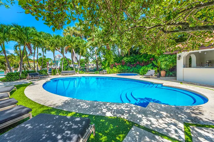 Secluded pool framed by dense tropical trees and lush garden landscaping.