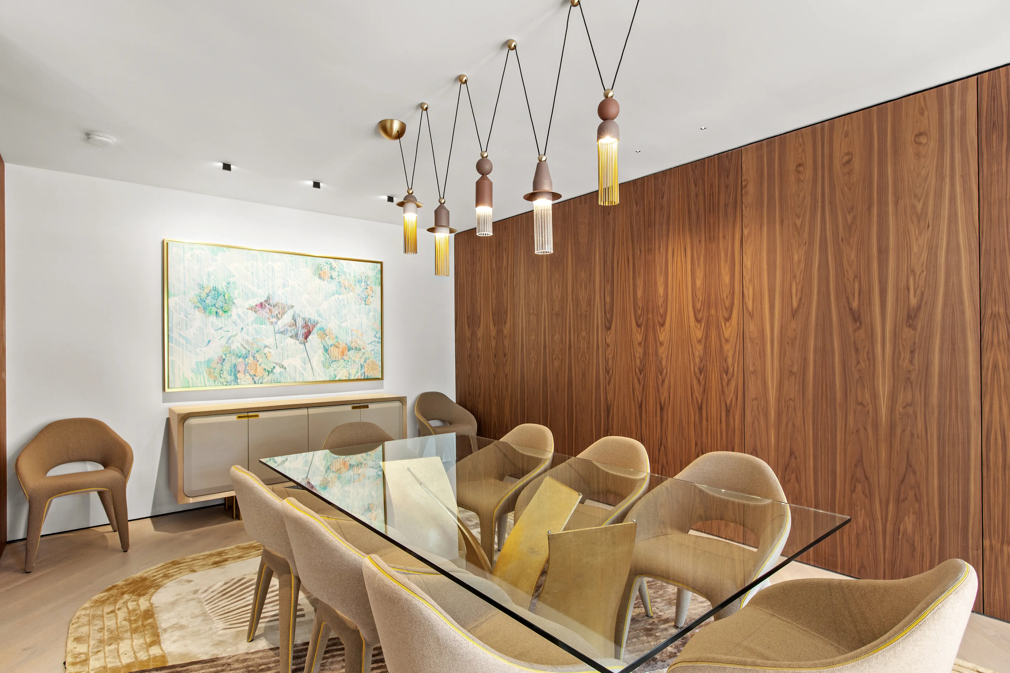 Sophisticated dining room featuring custom wood wall paneling, a glass dining table, sculptural lighting, and refined contemporary finishes in a Miami Beach residence.