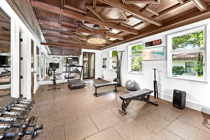 Spacious modern gym with high wood-paneled walls overlooking the central courtyard.