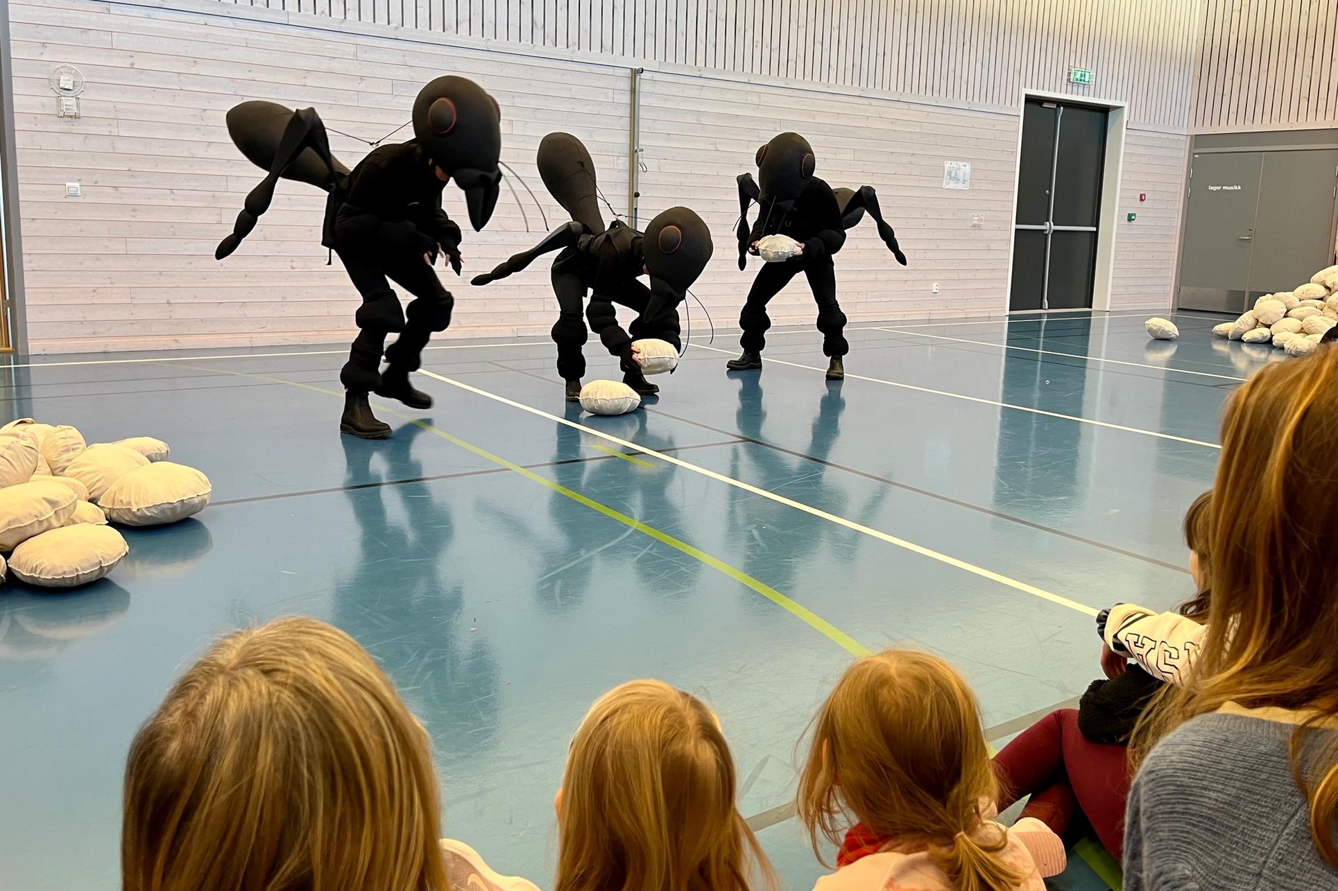 Tre dansere utkledd som maur, forestilling i gymsal