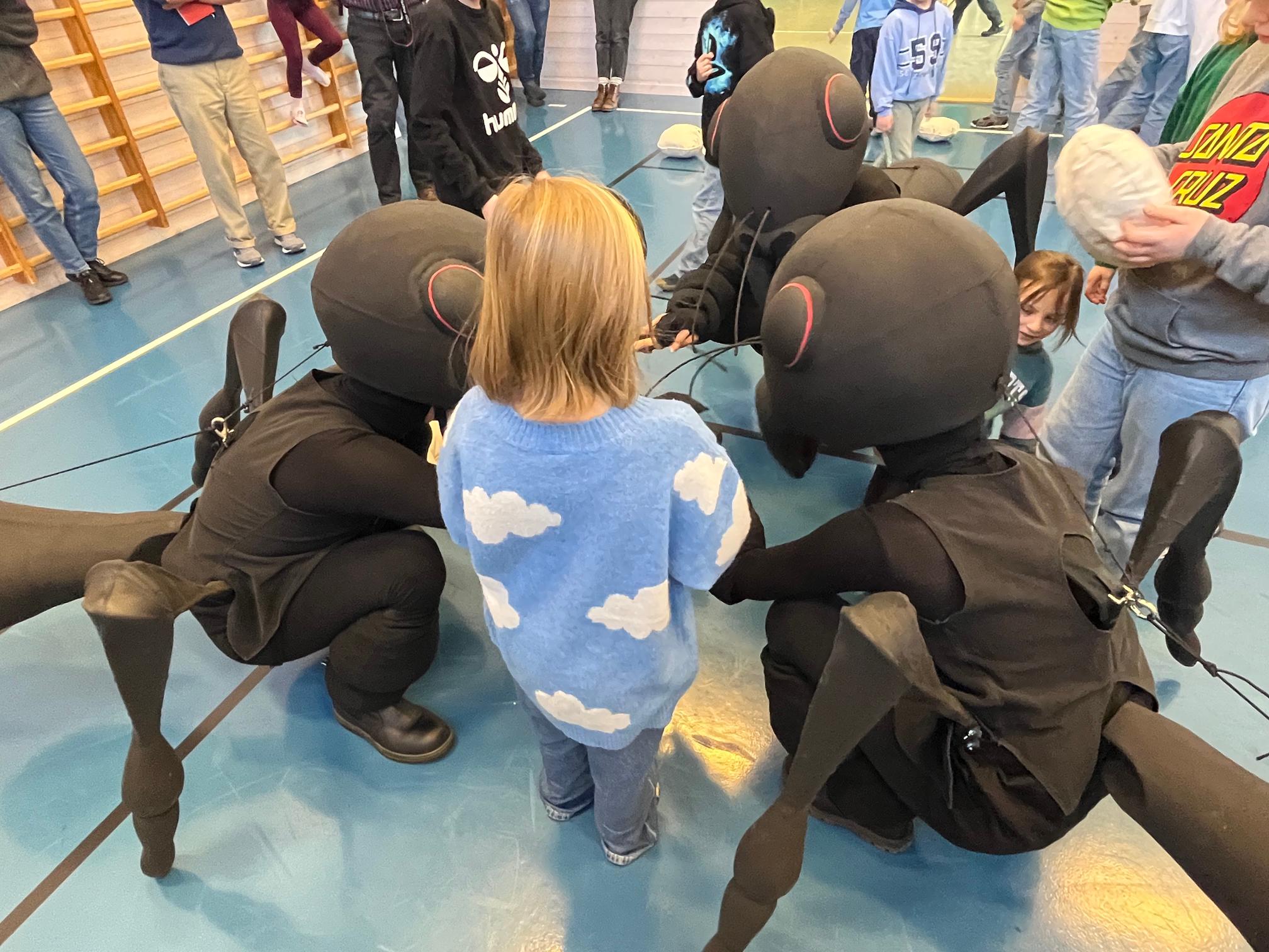 Tre dansere utkledde som maur gjør forestilling, i møte med barn og unge