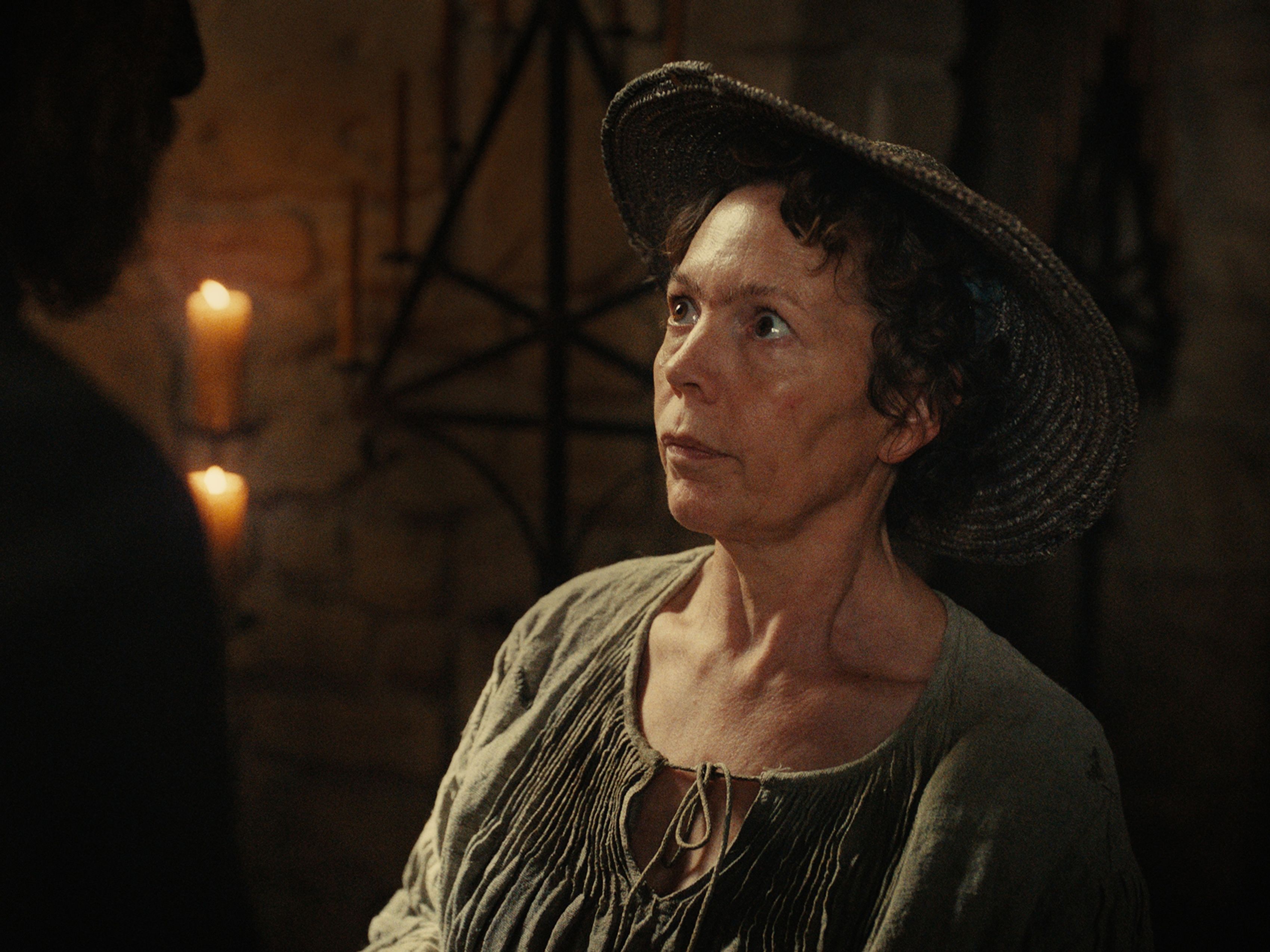 woman in old time dress with candles in background