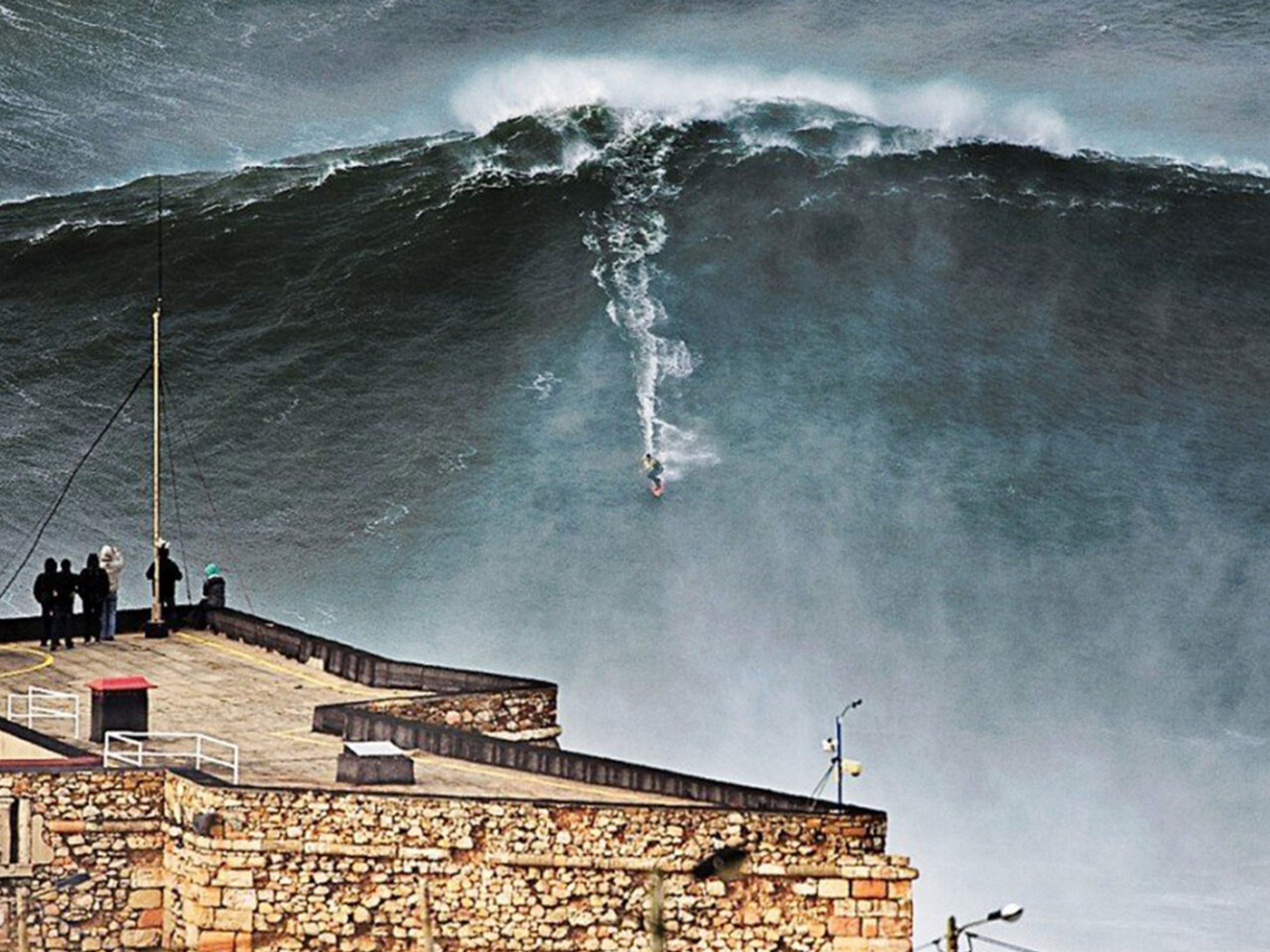 lighthouse surfer riding giant wave