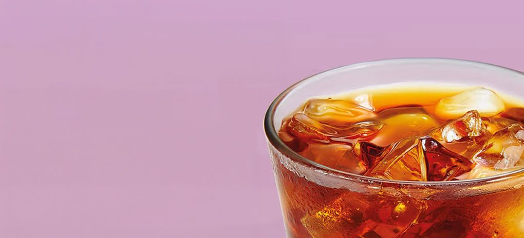 A picture of Cold Brew Coffee in a Glass on a pink background.