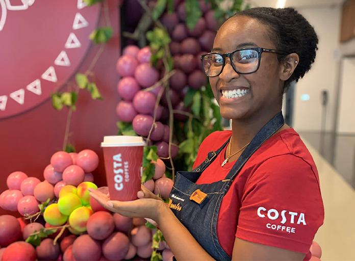 A person holding a takeaway cup of Costa Coffee