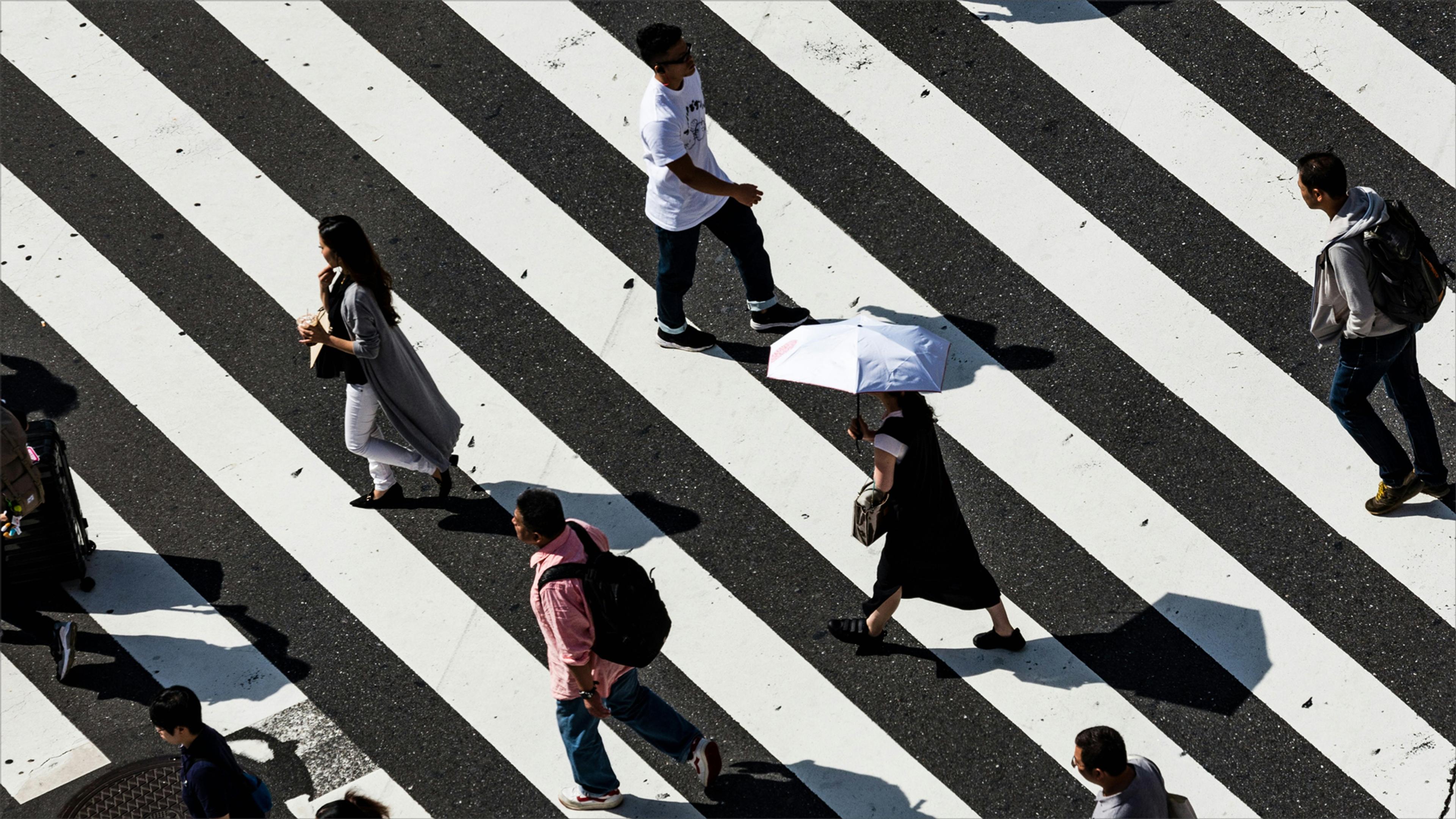 People walking across a large crosswalk