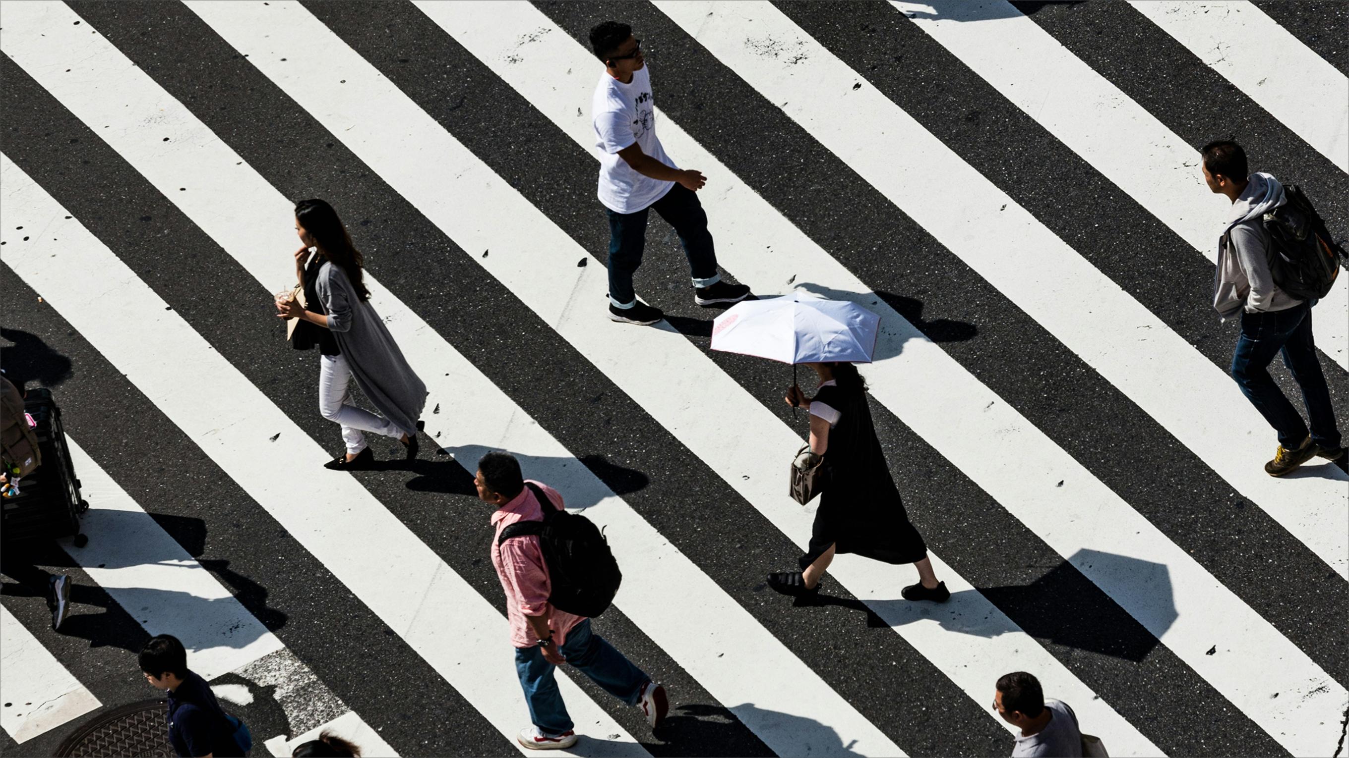 People walking across a large crosswalk