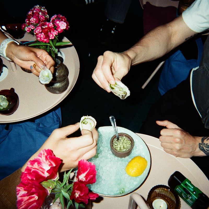Hands holding oysters at a restaurant