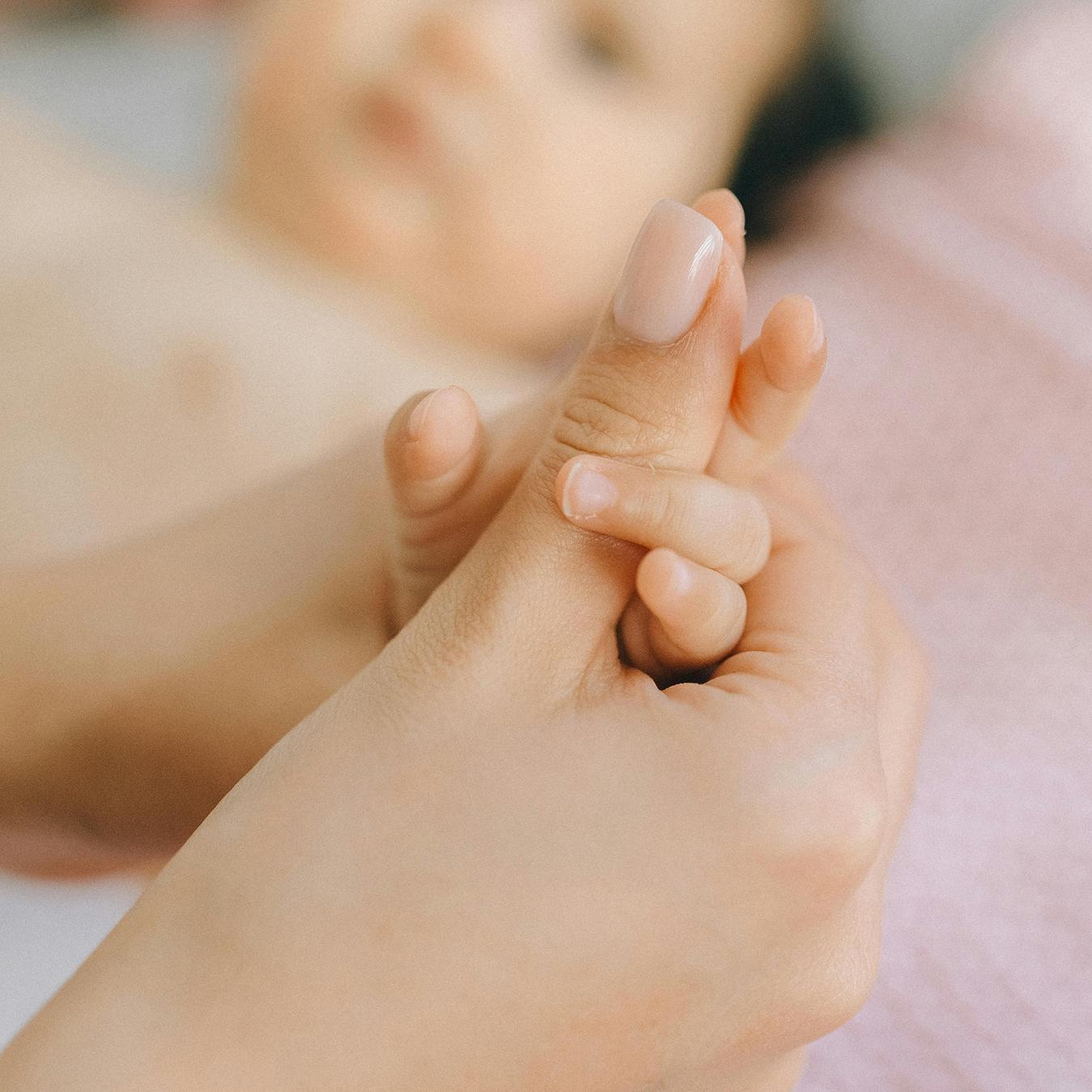 Close-up photo of an adult holding a child's hand