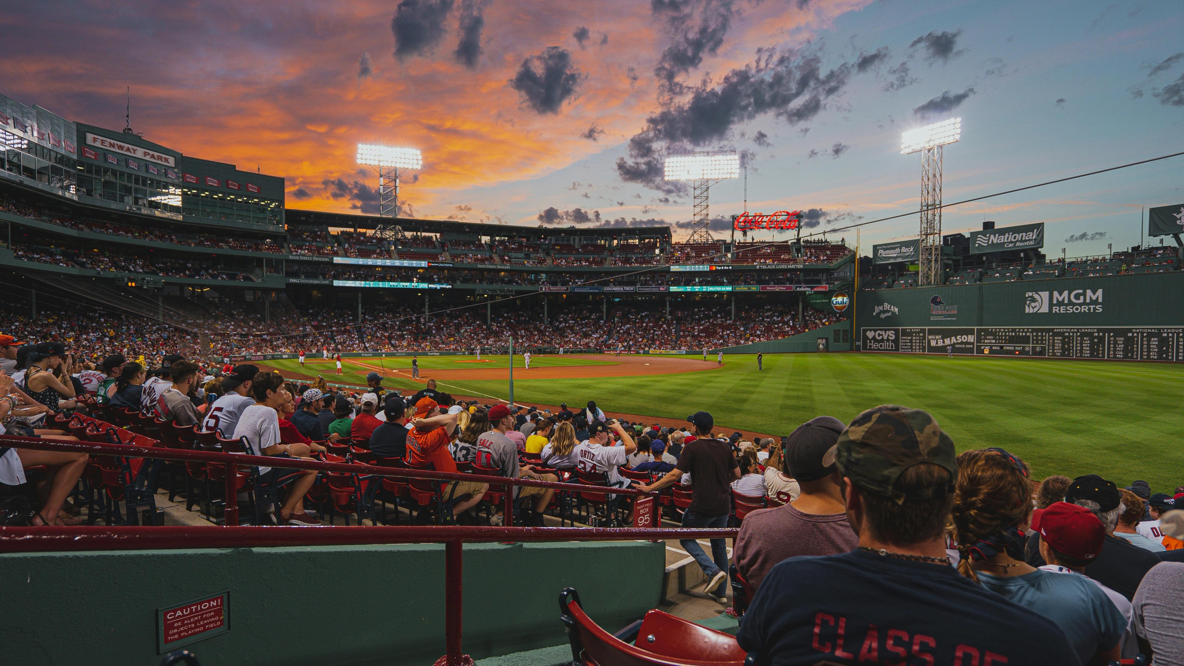 Fans in the stands at Fenway Park at sunset