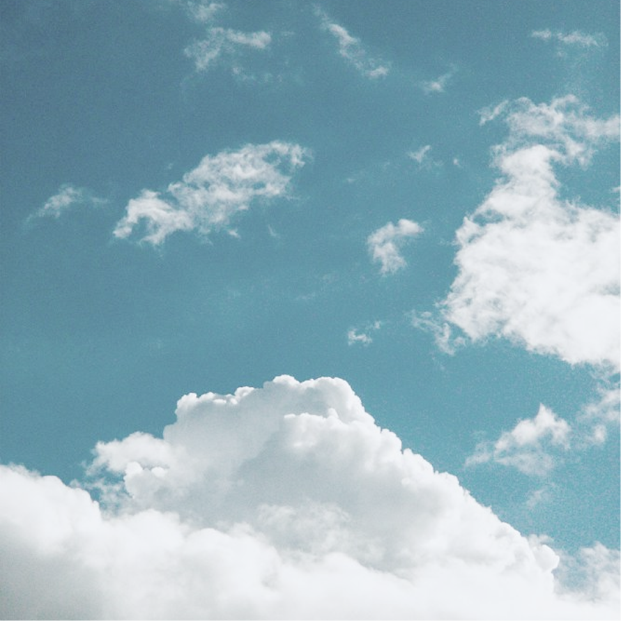 White clouds drifting across a teal sky