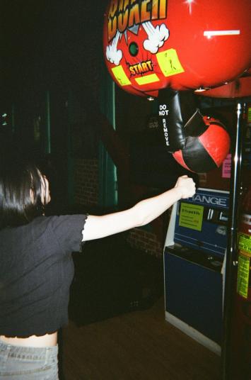 Woman punching an arcade game punching bag