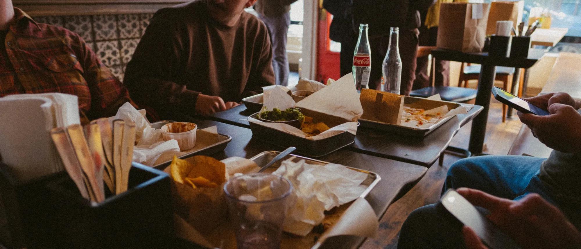 Team members gather around a restaurant table after sharing a casual lunch.