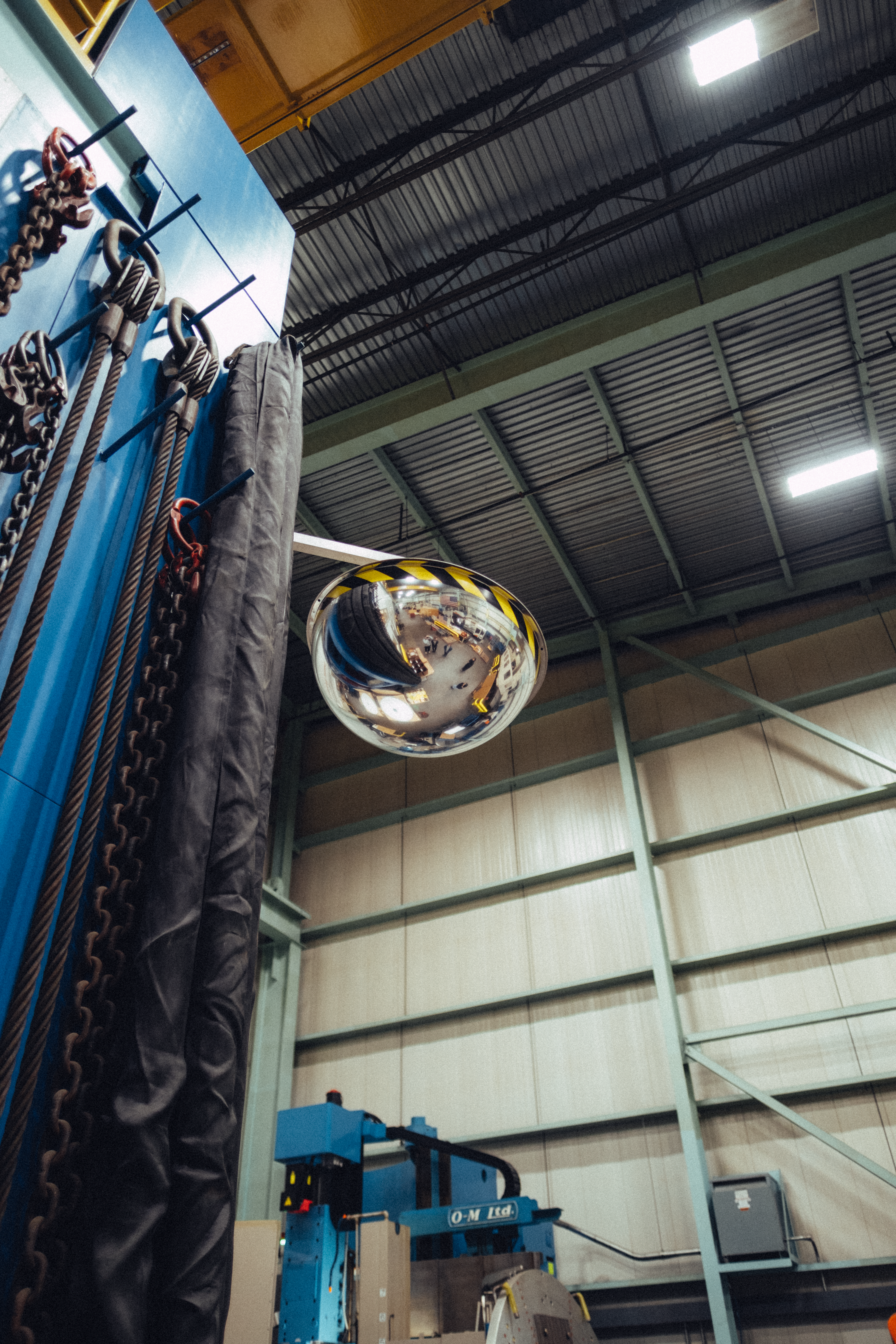 A mirrored convex dome reflecting an industrial warehouse setting