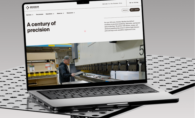 The Brodeur Machine site on a laptop, resting on a perforated steel work table