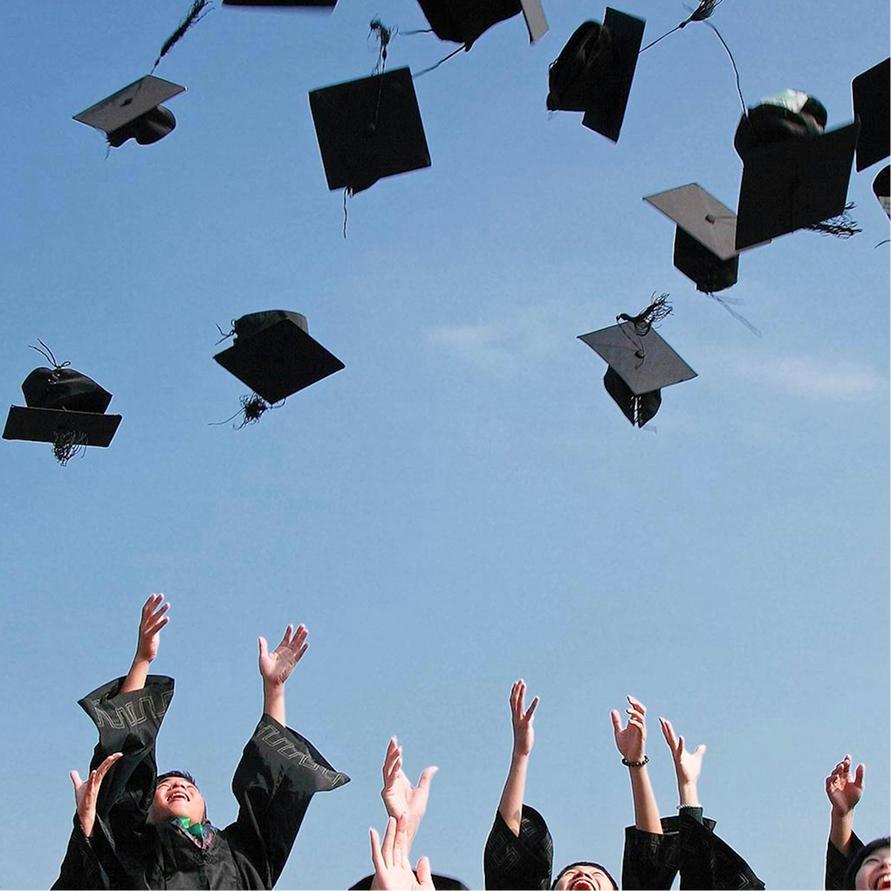 Graduates throwing their caps into a clear blue sky