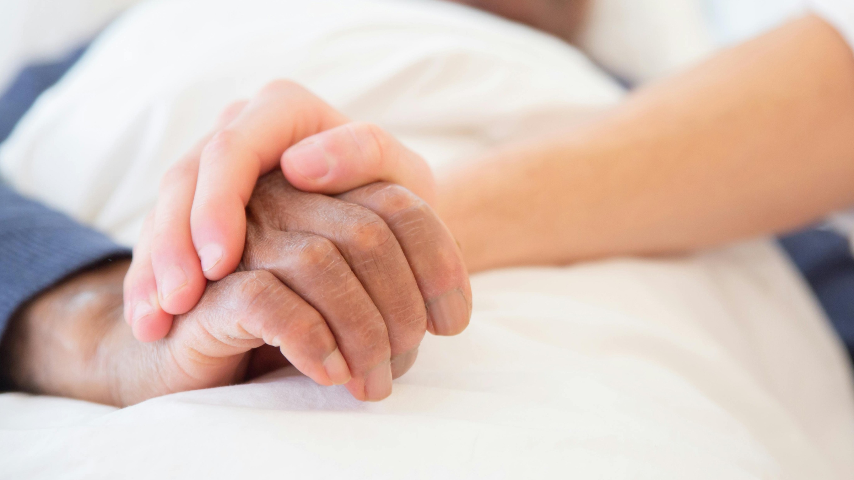 Young hand holding an older one