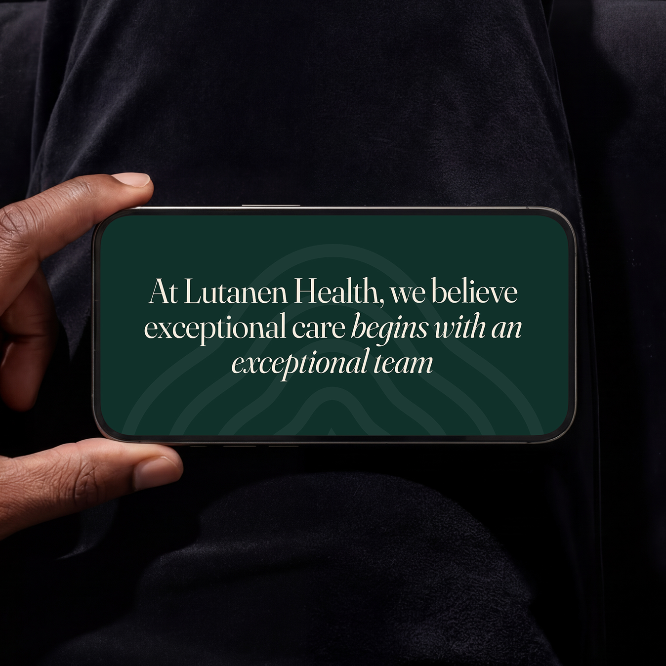 Hand holding a mobile phone with a quote on it "At Lutanen Health, we believe exceptional care begins with an exceptional team"
