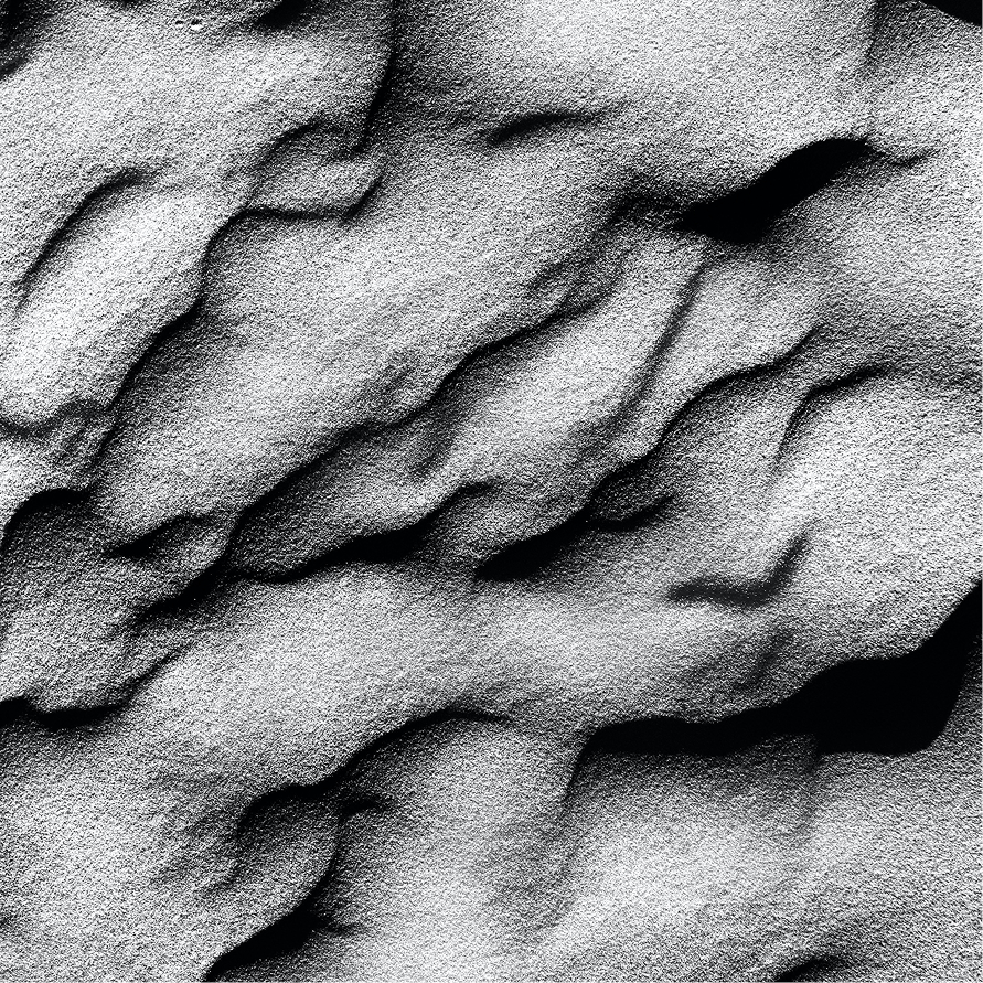 A close-up of wind-rippled sand in black and white