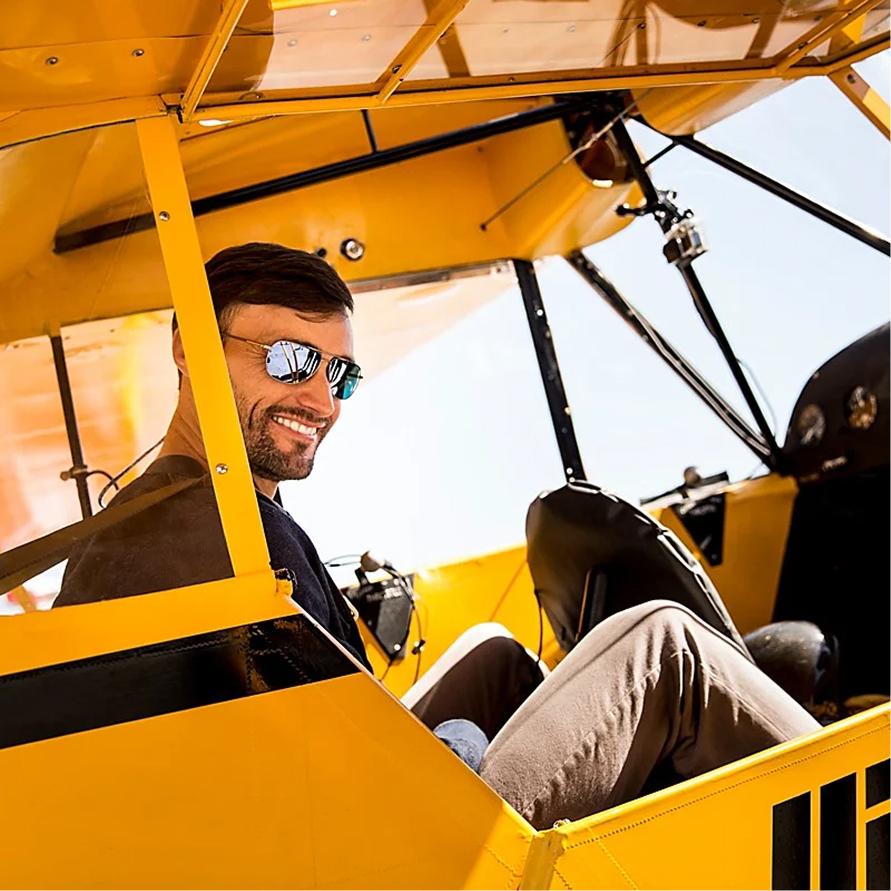 A man sitting in the pilot seat of a small aircraft