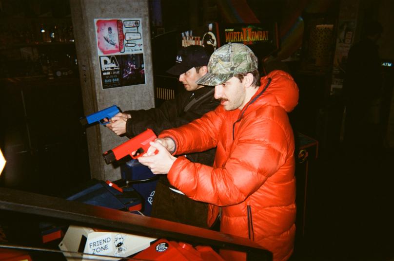 Two team members playing an arcade game