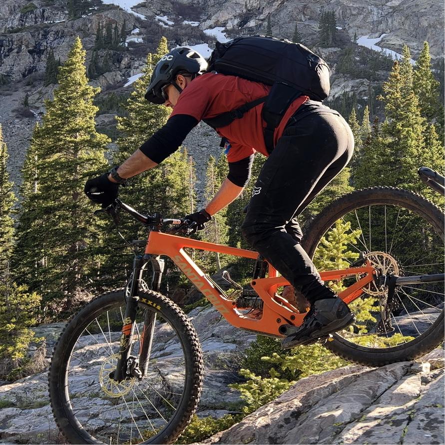 A mountain biker riding down a rocky alpine trail